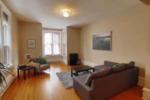 uma sala de estar com um sofá e uma televisão em Sunny and airy downtown apartment in Hull Gatineau em Gatineau
