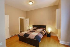 um quarto com uma cama num quarto com pisos em madeira em Sunny and airy downtown apartment in Hull Gatineau em Gatineau