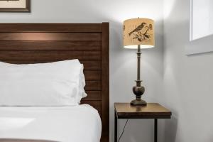 Capri Unit 001 in the Heart of Downtown TC في ترافيرس سيتي: مصباح على موقف ليلي بجوار سرير