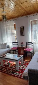 een woonkamer met een bank en een tafel en stoelen bij Niku HomeStay in Berat