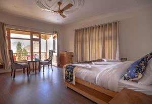 - une chambre avec un lit et une table avec des chaises dans l'établissement The Nangsay Hotel, à Leh