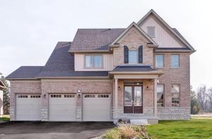 una casa con dos puertas de garaje en un patio en Spacious newly built PEC family home, en Carrying Place