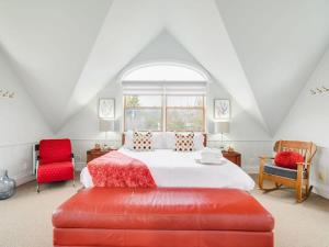 1 dormitorio con 1 cama y 2 sillas rojas en Stunning waterfront home 25min to downtown Ottawa en Gatineau