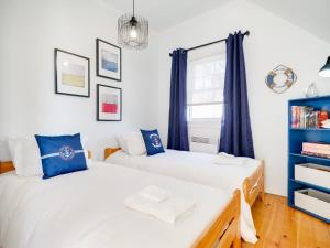 2 camas en un dormitorio con cortinas azules en Stunning waterfront home 25min to downtown Ottawa en Gatineau