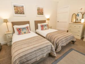 a bedroom with two beds and two night stands at Beechgrove Cottage - Pitmedden Gardens in Ellon