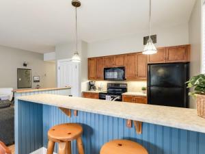 a kitchen with a counter and two stools at All Season Ski in out Chalet at Calabogie Peaks in Calabogie