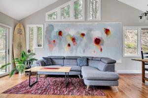 a living room with a couch and a painting at La Hacienda - Edelweiss après-ski - wooded escape in Val des Monts