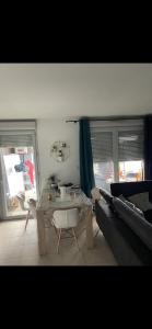 ein Wohnzimmer mit einem Tisch und einem Sofa in der Unterkunft Chambre dans un Appartement avec Parking privé in Toulouse