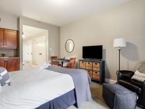 - une chambre avec un grand lit et une télévision dans l'établissement All Season Ski in Out Chalets at Calabogie Peaks, à Calabogie
