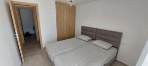 une chambre avec un grand lit avec une tête de lit en bois dans l'établissement Biserni Apartman 1, à Kotor