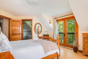 - une chambre avec un lit blanc et un miroir dans l'établissement Sunset Cove Waterfront nature retreat with bunkie, à Westport