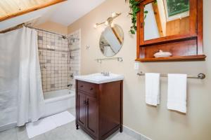 La salle de bains est pourvue d'un lavabo, d'une douche et d'un miroir. dans l'établissement Sunset Cove Waterfront nature retreat with bunkie, à Westport