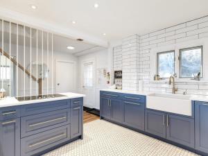 cocina con armarios azules y paredes blancas en Cozy family waterfront retreat recently renovated, en Deseronto