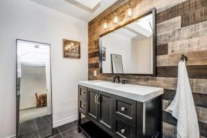 a bathroom with a sink and a mirror at Waterfront open concept dream cottage with hot tub in Portland +57 photos