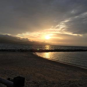 a sunset on the beach with the sun setting at Hôtel Paradis in Bormes-les-Mimosas