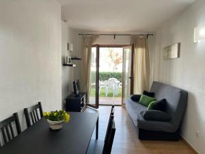 a living room with a couch and a table at Mestral -Apartamento con piscina junto la playa in Arenal d'en Castell