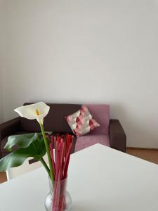 een vaas met een bloem op een tafel met een bank bij Tizi Apartments Porto in Maiori