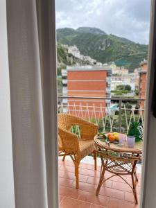 a balcony with a table and chairs and a view at Tizi Apartments Porto in Maiori +109 photos