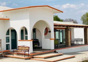 een wit huis met een bank op een patio bij Quinta Tequis San José in La Laja