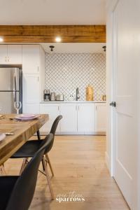 cocina con armarios blancos y mesa de madera en The Birch Suite at Portage House in Picton, en Picton