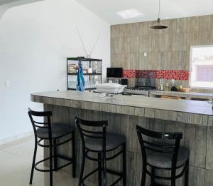 een keuken met 4 barkrukken en een aanrecht bij Quinta Tequis San José in La Laja