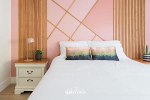 1 dormitorio con cama blanca y pared rosa en The Birch Suite at Portage House in Picton, en Picton