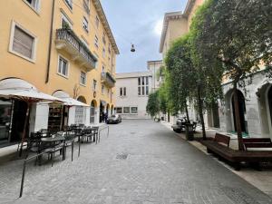 uma rua vazia com mesas, cadeiras e edifícios em Frame of Verona Apartments em Verona
