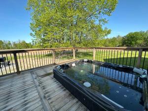 bañera de hidromasaje en una terraza con valla en Gorgeous private retreat with hot tub, en White Lake