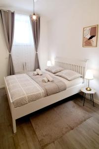 1 dormitorio con 1 cama blanca grande y ventana en A&Z APARTMENT en Zagreb