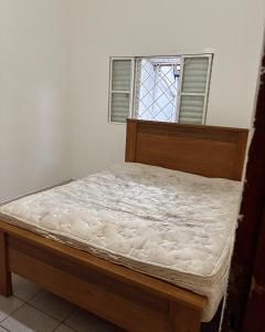 uma cama vazia num quarto com janela em Hostel do Mineiro em São José dos Campos