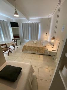 a bedroom with a bed and a table in it at Hotel Enseada in São Francisco do Sul