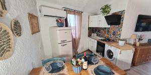 Una pequeña cocina con una mesa y un refrigerador. en Villa Sa Mama, en San Teodoro