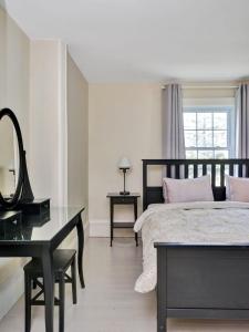 a bedroom with a bed with a mirror and a desk at Wind & Waves - Wellington waterfront with Satellite TV & fire pit in Wellington