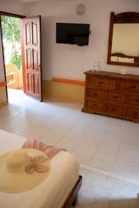 1 dormitorio con 1 cama con sombrero en Vista Caribe Playa en Playa del Carmen