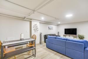 a living room with a blue couch and a tv at Downtown Albany Apartment Walk to Capitol! in Albany