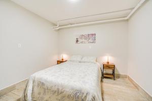 een witte slaapkamer met een bed en twee nachtkastjes bij Downtown Albany Apartment Walk to Capitol! in Albany