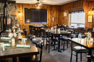 um restaurante com paredes e mesas e cadeiras de madeira em Desolation Hotel Hope Valley em Markleeville