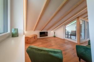 sala de estar con sofá verde y TV en Appartments DAS Hubertus, en Termeno