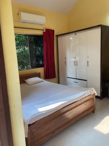 sypialnia z dużym łóżkiem i oknem w obiekcie Grace Air-conditioned Cool Homestay w mieście Benaulim
