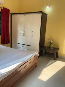 a bedroom with a large bed and a table at Grace Air-conditioned Cool Homestay in Benaulim
