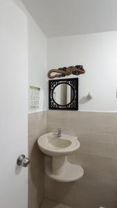baño con lavabo y espejo en la pared en Jackuri Casa Hospedaje, en San Andrés