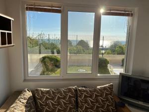 a living room with a couch and two windows at Квартира студия на берегу моря in Byala