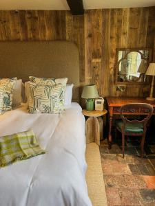 sypialnia z łóżkiem i biurkiem z lustrem w obiekcie The Fitz Farmhouse w mieście Swynnerton