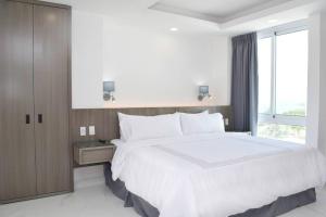 a bedroom with a large white bed and a window at New studio at the Beach, pool, gym, spa 2D in Cancún