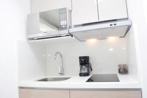 a kitchen with a sink and a microwave at New studio at the Beach, pool, gym, spa 2D in Cancún