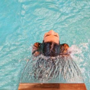 una persona flotando en una piscina en Hotel Piroska, en Bük