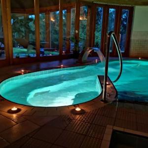 a large swimming pool with lights in a house at Hotel Piroska in Bük