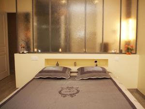 a bedroom with a bed with two pillows on it at Ô Délices de la Monnerie in Bourgnac