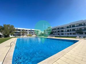 a swimming pool in front of a building at Yes Centro de Vilamoura Saturno T1 in Quarteira