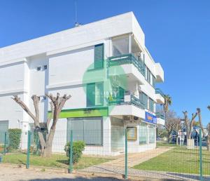 a white building with green doors and windows at Yes Centro de Vilamoura Saturno T1 in Quarteira